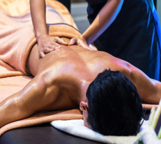 Therapist giving a back massage to a client on a massage table.