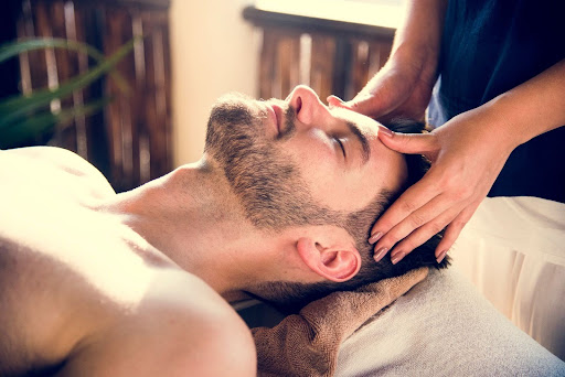 Man getting a relaxing head massage during a spa therapy session.