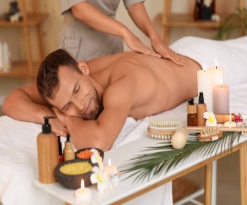 Man relaxing during a professional massage with spa setup.